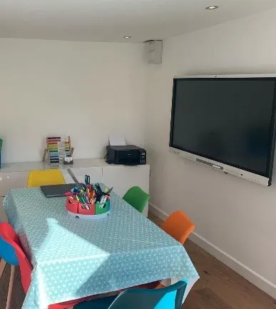 Learning table and teaching screen inside the Mrs P Tutoring classroom